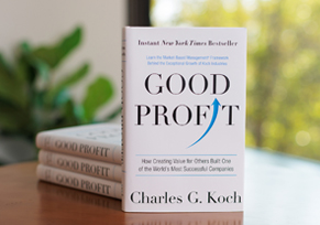 A hardcover copy of Good Profit by Charles Koch, standing upright against a neutral gradient background.